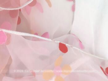 Voici  un coupon de voilage polyester opaque décoré de fleurs roses, orangées et grises dans la tendance seventeen de 165 de large plombé sur un coté et 180 cm de long.  Original !