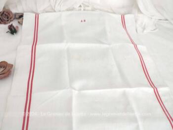 Voici deux anciens torchons en drap de lin brodé au point de croix des lettres AM  en fils rouges au point de croix et décorés de fines bandes rouges.