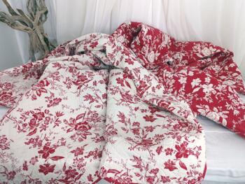 Voici un superbe couvre-lit en boutis matelassé de 260 x 190 cm avec deux faces différentes de fleurs en positif/négatif, sur fond carmin et blanc.