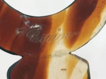 Sur 12 x 5.5 x0.2 cm, voici un superbe ancien peigne à chignon à deux dents, datant surement des années 40/50 et réalisé en rhodoïd imitation corne et portant une estampille presque illisible.