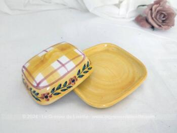 Voici un petit beurrier en céramique sur fond jaune en deux parties, avec sur le couvercle cadrillage et une guirlande de fleurs. Estampillé 