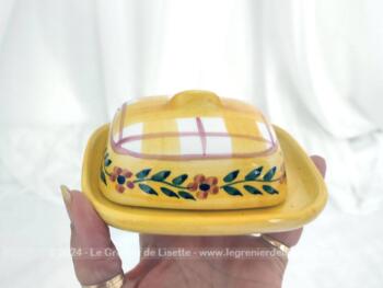 Voici un petit beurrier en céramique sur fond jaune en deux parties, avec sur le couvercle cadrillage et une guirlande de fleurs. Estampillé 