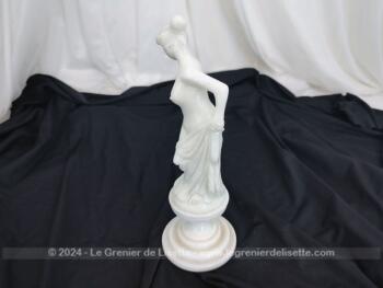 Voici une belle statuette, sculpture en albâtre blanc d'une jeune femme dévêtue, son vêtement glissant le long de ses jambes et tenant sa chaussure.  Superbe !