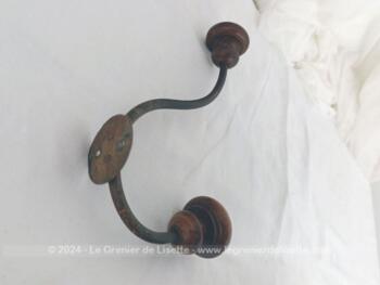 Voici une ancienne patère double avec embouts en bois bien ouvragés et le corps en métal, le tout bien patiné par le temps. A. vec écusson percé pour la fixer