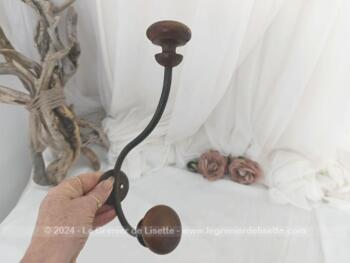 Voici une ancienne patère double avec embouts en bois bien ouvragés et le corps en métal, le tout bien patiné par le temps. A. vec écusson percé pour la fixer