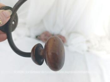 Voici une ancienne patère double avec embouts en bois bien ouvragés et le corps en métal, le tout bien patiné par le temps. A. vec écusson percé pour la fixer
