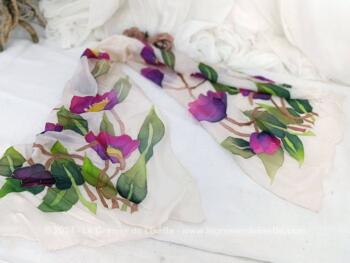 Sur 40 x 140 cm, voici une belle écharpe en soie naturelle ivoire avec aux deux extrémités de larges décors de fleurs peintes à la main dans des tons de mauve, jaune et verts et portant une signature.