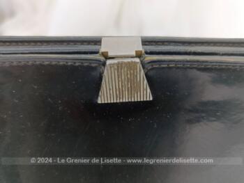 Voici un sac vintage en cuir vernis noir avec une poche intérieure simple et une fermée par une fermeture éclair. Il se ferme par un fermoir à clapet. Sa anse lui permet de le porter à la main, au bras et même à l'épaule. Top vintage !