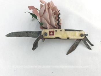 Habillage bakélite imitation nacre avec de petits manques, voici ancien petit couteau Suisse vintage avec ses 6 petits outils ou ustensiles bien patinés par le temps. Drapeau Suisse sur le manche.