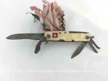 Habillage bakélite imitation nacre avec de petits manques, voici ancien petit couteau Suisse vintage avec ses 6 petits outils ou ustensiles bien patinés par le temps. Drapeau Suisse sur le manche.