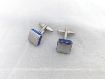 Voici une paire de boutons de manchettes vintages représentant un carré de verre couleur bleu cobalt serti dans un habillage de métal argenté.
