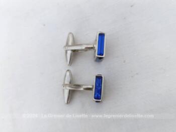 Voici une paire de boutons de manchettes vintages représentant un carré de verre couleur bleu cobalt serti dans un habillage de métal argenté.