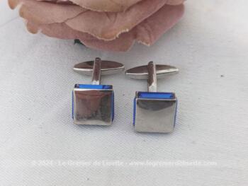 Voici une paire de boutons de manchettes vintages représentant un carré de verre couleur bleu cobalt serti dans un habillage de métal argenté.