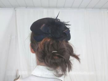 Superbe chapeau bibi en feutre noir avec au dos une décoration avec plumes, duvet et noeud satin noir. A l'intérieur, un élastique pour maintenir les cheveux et une étiquette 