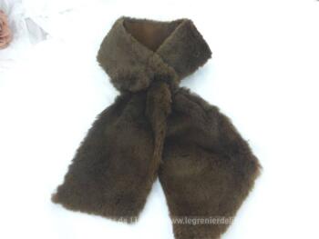 Superbe tour de cou façon cravate en douce et belle imitation fourrure de couleur chocolat au lai avec une large boutonnière d'un coté pour faire passer l'autre coté et le serrer . Top vintage .
