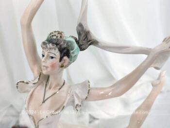 Sur 50 cm de haut et 40 cm de large et posée sur un socle en bois, voici une belle statuette en résine, représentant une danseuse exécutant un grand jeté mettant en valeur le voile de sa robe et celui de son étole. Superbe !