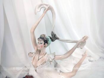 Sur 50 cm de haut et 40 cm de large et posée sur un socle en bois, voici une belle statuette en résine, représentant une danseuse exécutant un grand jeté mettant en valeur le voile de sa robe et celui de son étole. Superbe !
