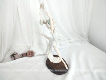 Sur 50 cm de haut et 40 cm de large et posée sur un socle en bois, voici une belle statuette en résine, représentant une danseuse exécutant un grand jeté mettant en valeur le voile de sa robe et celui de son étole. Superbe !