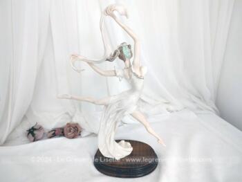 Sur 50 cm de haut et 40 cm de large et posée sur un socle en bois, voici une belle statuette en résine, représentant une danseuse exécutant un grand jeté mettant en valeur le voile de sa robe et celui de son étole. Superbe !