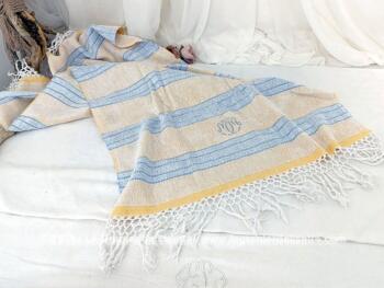 Sur un fond jaune,  voici une ancienne serviette de toilette en éponge fine sur 62 x 104 cm, brodée des monogrammes MM et décorée de rayures bleu ciel et de superbes franges de 10 cm à chaque extrémités.