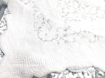 Voici un superbe couvre-lit en boutis matelassé de 265 x 210 cm avec une face unie gris souris et une face taupe avec des branches et volutes brodées. Beaucoup de charme et tendance shabby.