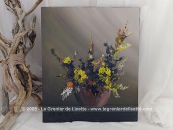 Sur 33.5 x 40 cm,  voici un bien original tableau réalisé en peinture à l'huile sur bois représentant sur un fond couleur taupe, une bouquet de fleurs à dominante jaune dans un vase posé sur un socle. Une signature visible semble indiquer 