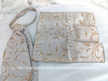 Voici une belle cravate Ascot à l'allure vintage en tissus 100% polyester beige aux dessins de volutes couleur caramel surlignées d'un liseré brillant avec une pochette assortie.