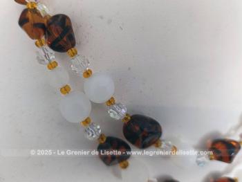 Collier vintage en double rangs réalisé avec des perles de verre couleur ambre, couleur opaque et translucides le tout en taille croissante , entremêlées par des petites perles ocre entre chaque perles. Fermoir avec strass.
