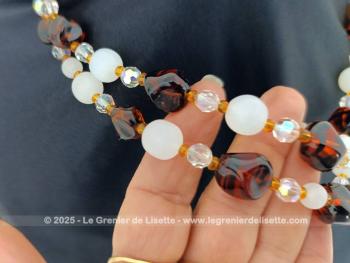 Collier vintage en double rangs réalisé avec des perles de verre couleur ambre, couleur opaque et translucides le tout en taille croissante , entremêlées par des petites perles ocre entre chaque perles. Fermoir avec strass.