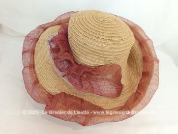 Voici une capeline en paille avec décorations de sisal couleur rouille et framboise sur toute la bordure, sur le corps et sur le revers du coté largement relevé.