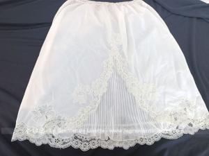De la marque Kalinka des années 50/60, voici un superbe et original jupon vintage court  blanc cassé avec dentelle et un superbe empiècement plissé avec une taille élastiquée pouvant convenir d'une taille 36 à un petit 40.
