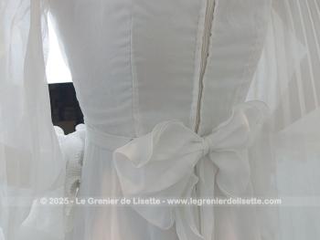 Taille 34 voire peut-etre un petit 36,  voici un modèle très rétro avec cette ancienne robe de mariée avec son majestueux plissé dessiné sur la partie basse et ses grandes manches. Unique et vraiment sublime !