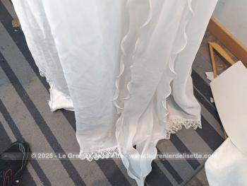 Taille 34 voire peut-etre un petit 36,  voici un modèle très rétro avec cette ancienne robe de mariée avec son majestueux plissé dessiné sur la partie basse et ses grandes manches. Unique et vraiment sublime !