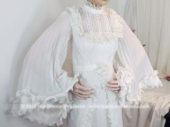 Taille 34 voire peut-etre un petit 36,  voici un modèle très rétro avec cette ancienne robe de mariée avec son majestueux plissé dessiné sur la partie basse et ses grandes manches. Unique et vraiment sublime !