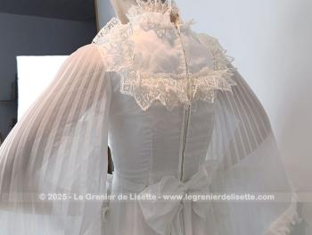 Taille 34 voire peut-etre un petit 36,  voici un modèle très rétro avec cette ancienne robe de mariée avec son majestueux plissé dessiné sur la partie basse et ses grandes manches. Unique et vraiment sublime !