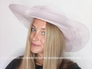Voici un large chapeau bien orignal réalisé en sisal synthétique de couleur rose pâle, avec un large rebord, noeuds et ruban pour un style très 
