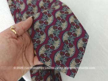 Voici une superbe cravate de la marque Paco Rabanne Paris,  parée de motifs décorés gris et taupe sur fond bordeaux avec doublure estampillée Paco Rabanne.