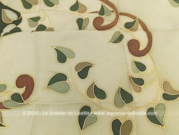En soie, voici un foulard signé de 70 x 65 cm entièrement peint à la main sur la base de deux tons de vert qui mettent en avant des feuilles vertes et marron. Une signature au stylo pour une pièce unique.