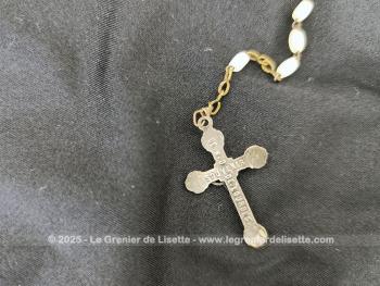 Sur 44 cm de long, voici un chapelet vintage avec une croix en métal argenté superbement ouvragée, monté avec des perles de verre translucides ovales à facettes. Au dos de la croix, l'inscription 