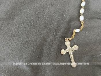 Sur 44 cm de long, voici un chapelet vintage avec une croix en métal argenté superbement ouvragée, monté avec des perles de verre translucides ovales à facettes. Au dos de la croix, l'inscription 