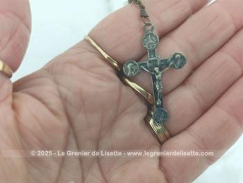Sur 44 cm de long, voici un chapelet vintage avec une croix en métal argenté superbement ouvragée, monté avec des perles de verre translucides ovales à facettes. Au dos de la croix, l'inscription 