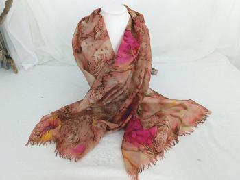 Sur 44 x 153 cm, voici une belle écharpe en soie naturelle peinte à la main décorée avec des motifs, façon peinture délavée des tons orangée et fuchsia et avec un petit peu de vert. 