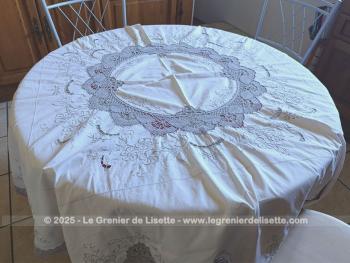Belle nappe ronde en coton écru de 160 cm de diamètre décorées par de belles broderies simples et ajourées, et habillée par des incrustations de dentelles couleur taupe réalisées au crochet. Superbe.