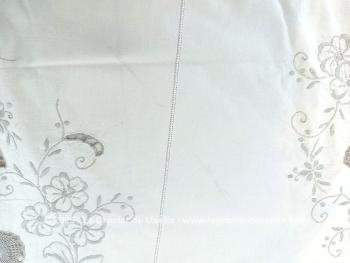 Belle nappe ronde en coton écru de 160 cm de diamètre décorées par de belles broderies simples et ajourées, et habillée par des incrustations de dentelles couleur taupe réalisées au crochet. Superbe.