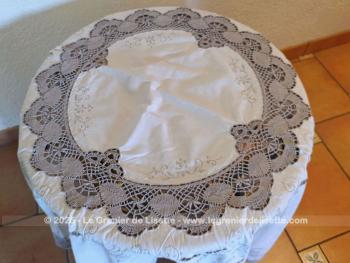 Belle nappe ronde en coton écru de 160 cm de diamètre décorées par de belles broderies simples et ajourées, et habillée par des incrustations de dentelles couleur taupe réalisées au crochet. Superbe.