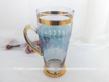 Très vintage ce grand pichet en verre, des années 60/70 décoré par des dessins en verre gravé et des larges bandes dorées, sans oublier un fond bleu.