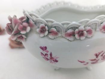 Tous les détails de cette petite jardinière ne sont que ravissement: les pieds en relief, les dessins de gerbes de fleurs roses, la guirlande de petites roses en relief surmontée d'un délicat tressage. Une vraie merveille !