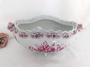 Tous les détails de cette petite jardinière ne sont que ravissement: les pieds en relief, les dessins de gerbes de fleurs roses, la guirlande de petites roses en relief surmontée d'un délicat tressage. Une vraie merveille !