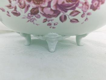 Tous les détails de cette petite jardinière ne sont que ravissement: les pieds en relief, les dessins de gerbes de fleurs roses, la guirlande de petites roses en relief surmontée d'un délicat tressage. Une vraie merveille !