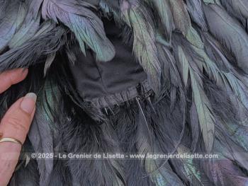 Taille 42,  voici une belle jupe courte, élégante et théâtrale à la fois, toute en plumes noires aux reflets irisés, portant l'étiquette de la marque  française reconnue pour ses créations audacieuses 